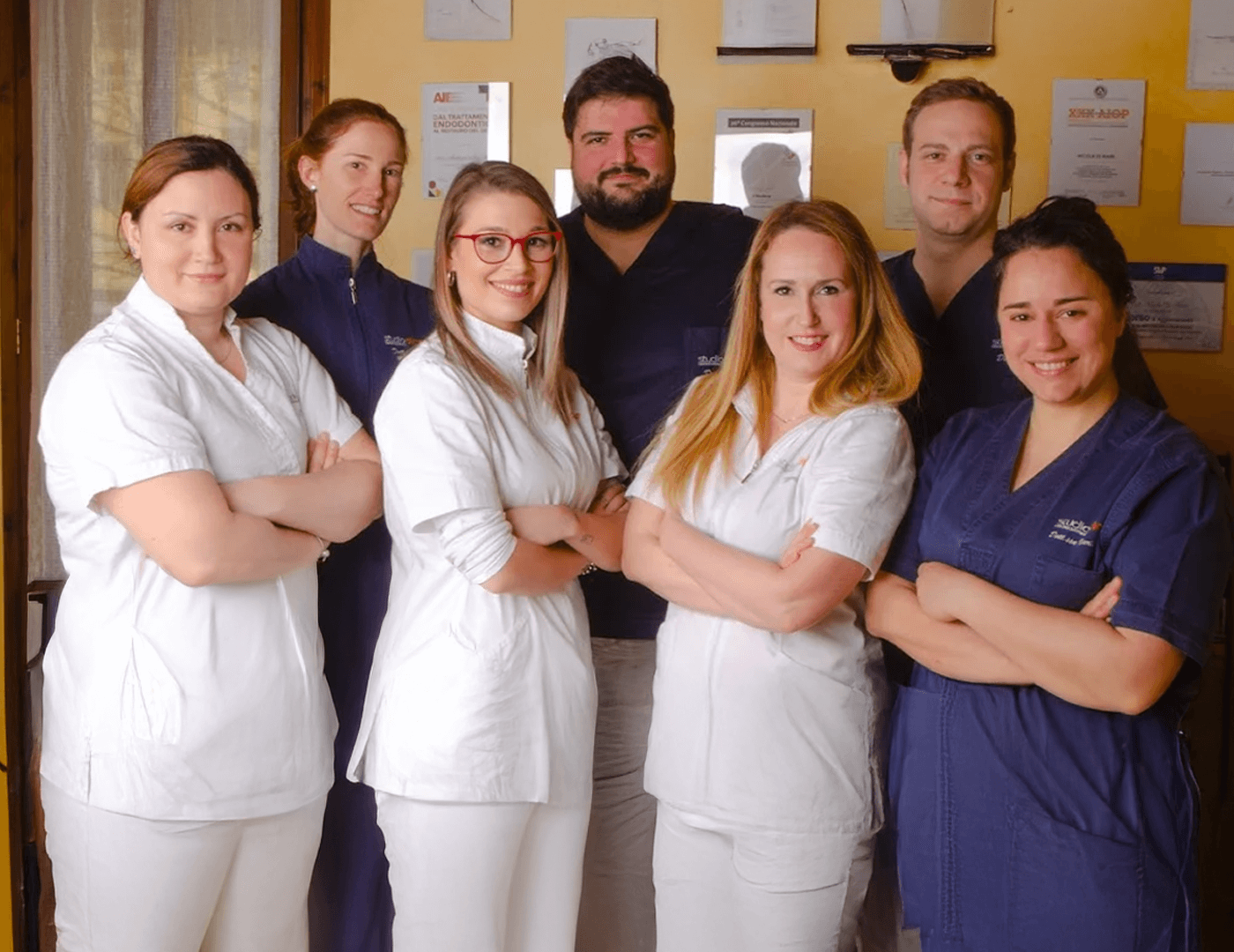 Foto di gruppo dello staff dello studio dentistico sorridente in divisa medica.